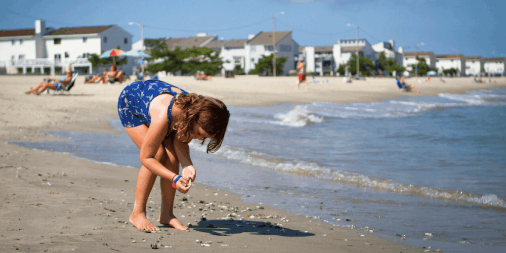 Young girl searches through seashells on the shore of Buckroe Beach in Hampton, Virginia