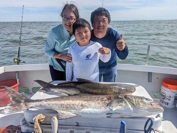 Family posing with cobia caught on fishing trip with Captain Hogg's Charter Service.
