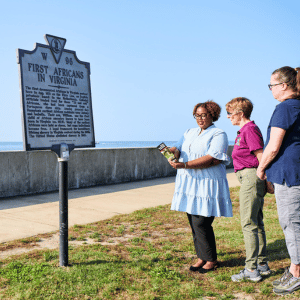 group of tourists looking at the historical marker for the First Africans in Virginia