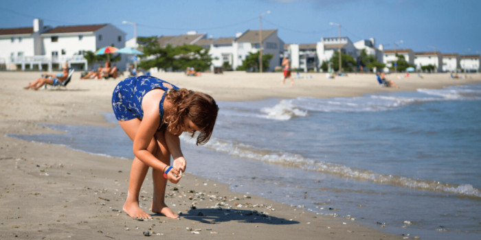 Young girl searches through seashells on the shore of Buckroe Beach in Hampton, Virginia