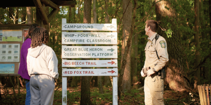two girls and park ranger beside trail signs at Sandy Bottom Nature Park
