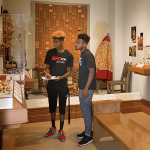 two young black men study African art exhibit at Hampton University Museum